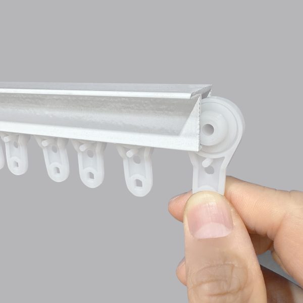 A white Fabtex drapery ball bearing carrier is inserted into a white drapery track