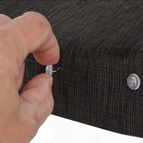 A hand screwing the Fabtex upholstery twist pin into the fabric